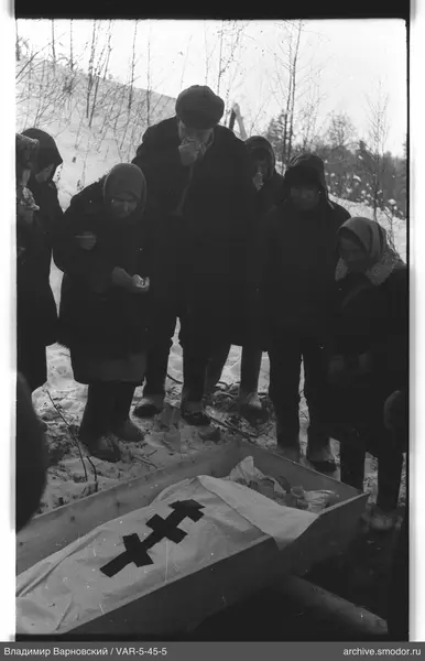 Группа у деревянного гроба на снегу