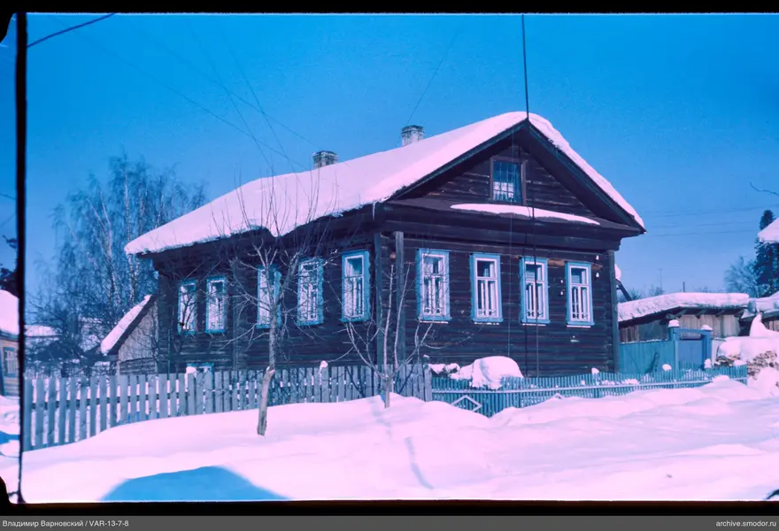 Wooden house with snow and fence