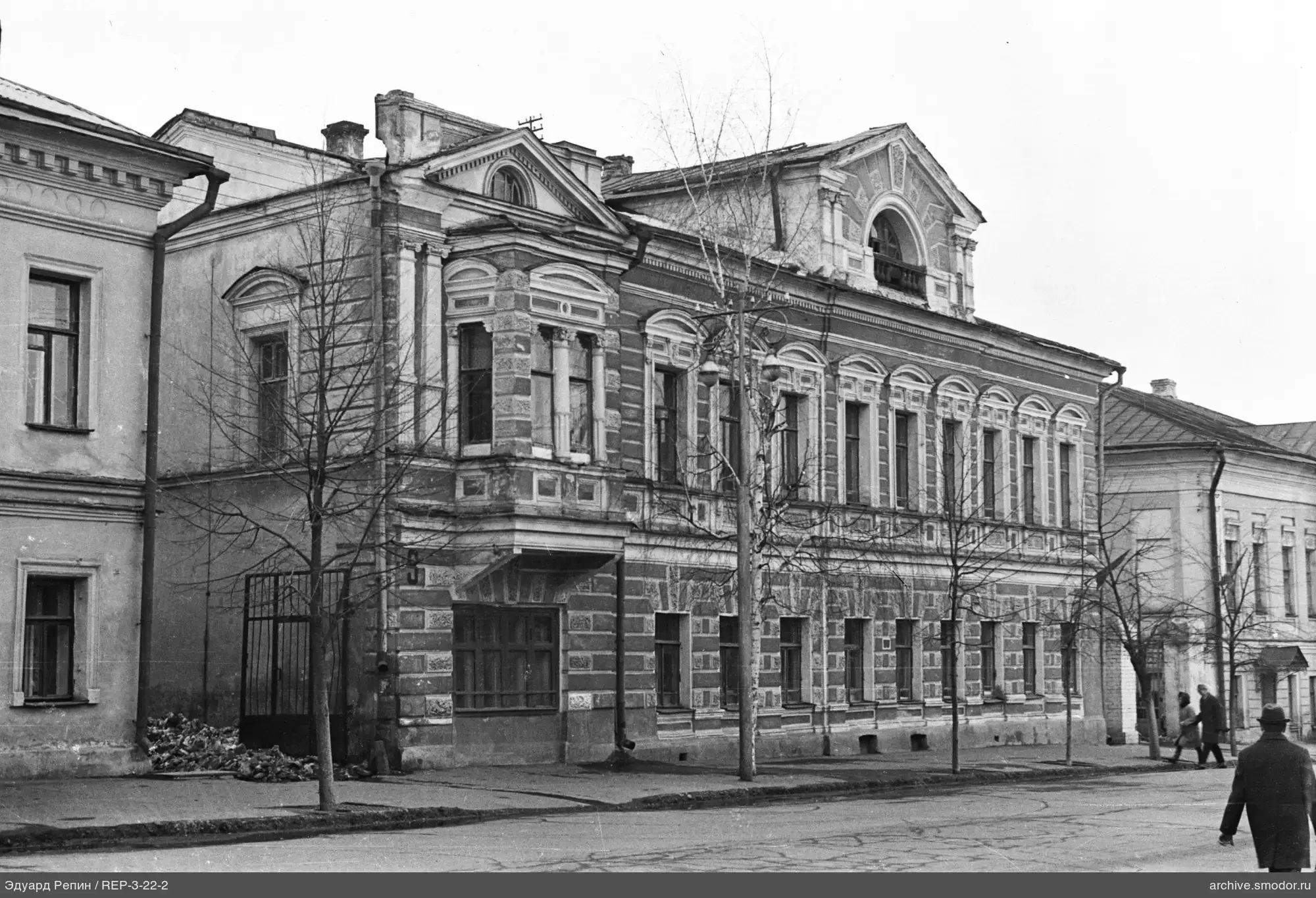 Two-story stone building with people on the street