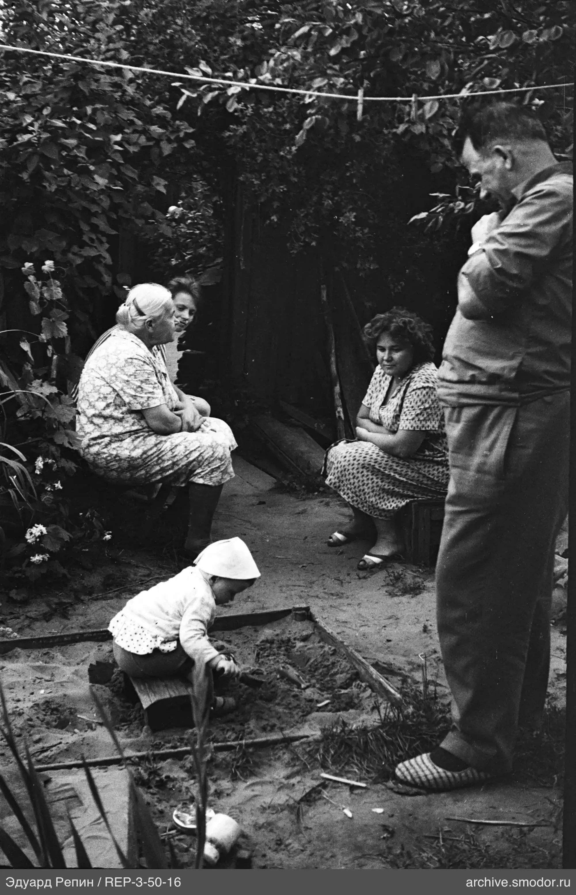Kinder und Erwachsene beim Picknick am Zaun