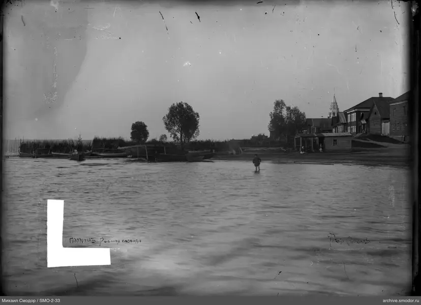 Человек в воде у береговых домов