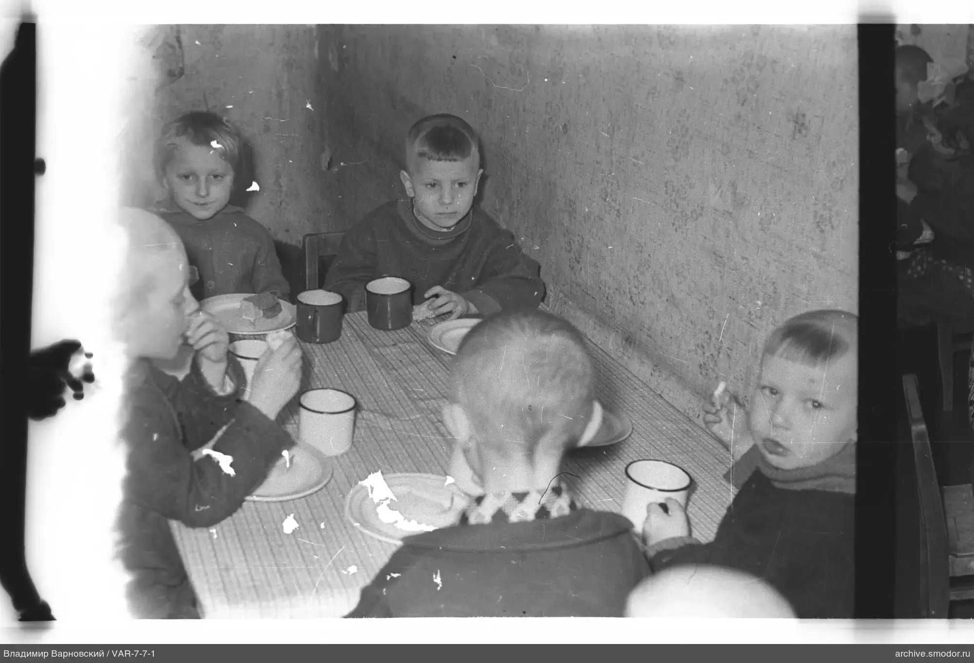Kinder am Tisch mit Brot und Geschirr