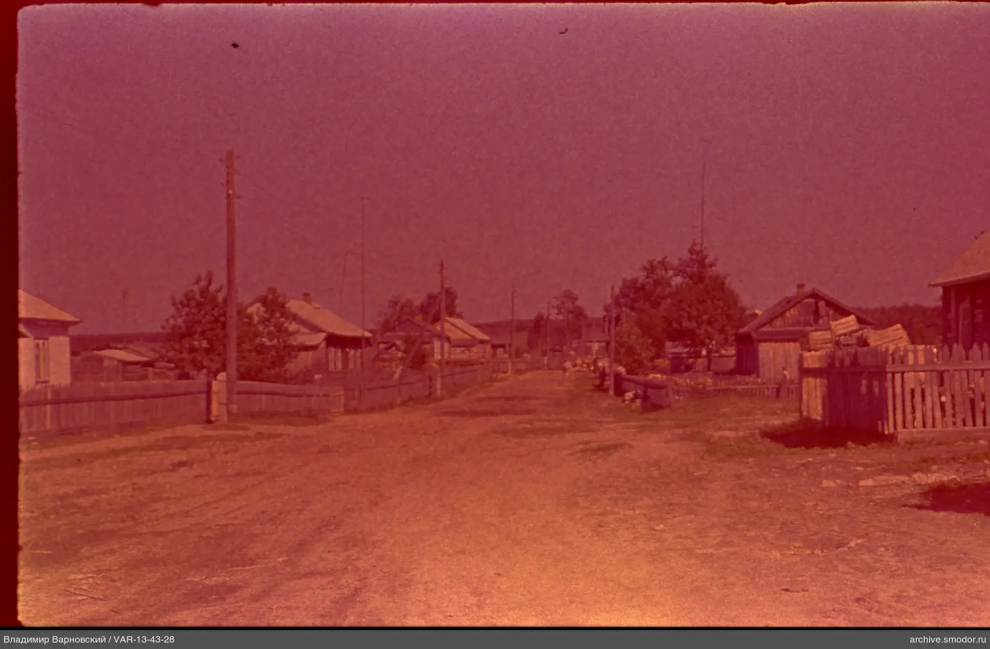 Dorfstraße mit Häusern und Wald