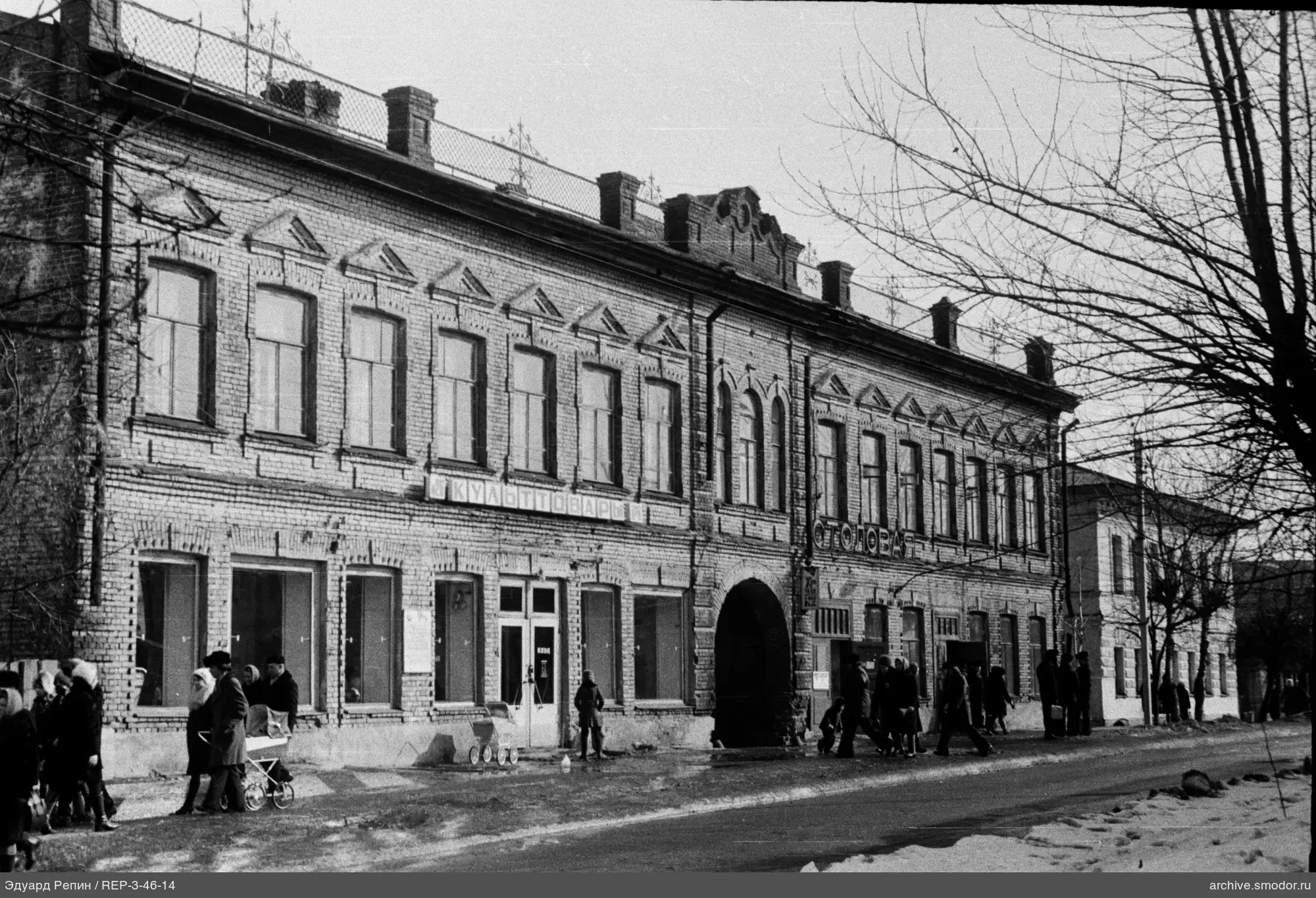 Двухэтажное кирпичное здание с арочным проходом