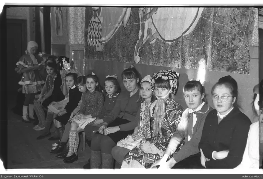 Gruppe von Mädchen und Frau vor Wand mit Panel