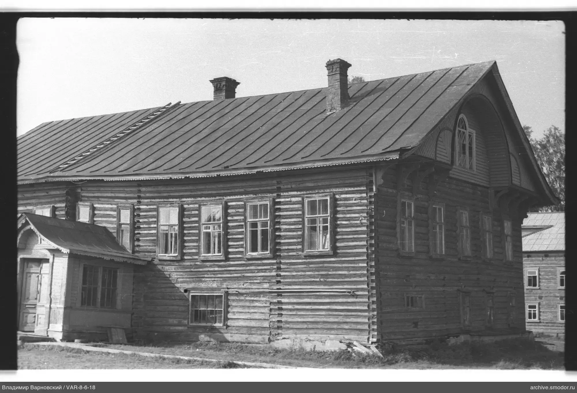 Two-story wooden building with roof and chimneys