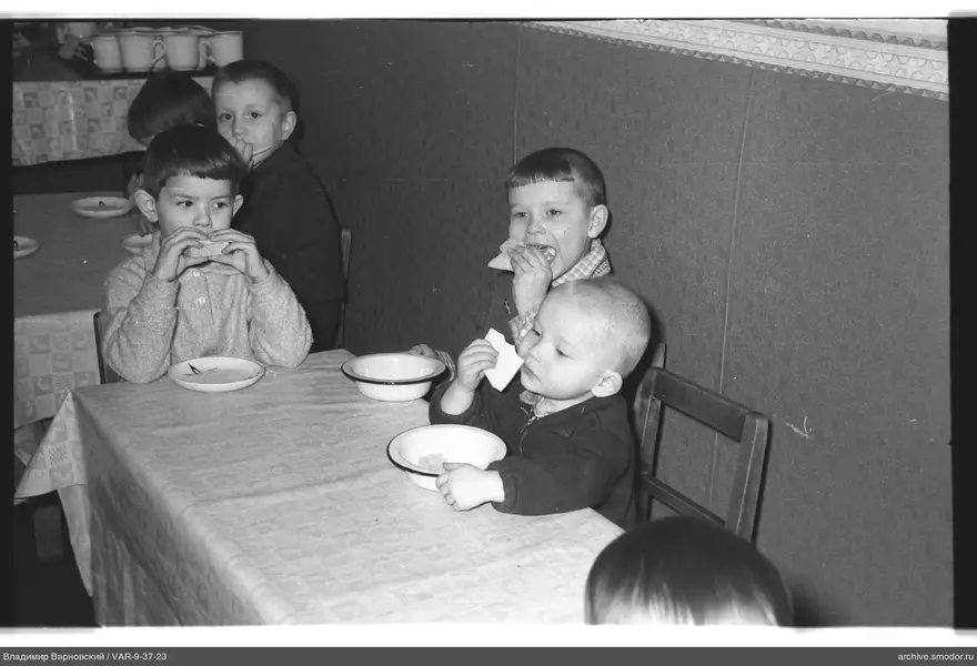 Children sitting at a table with bread