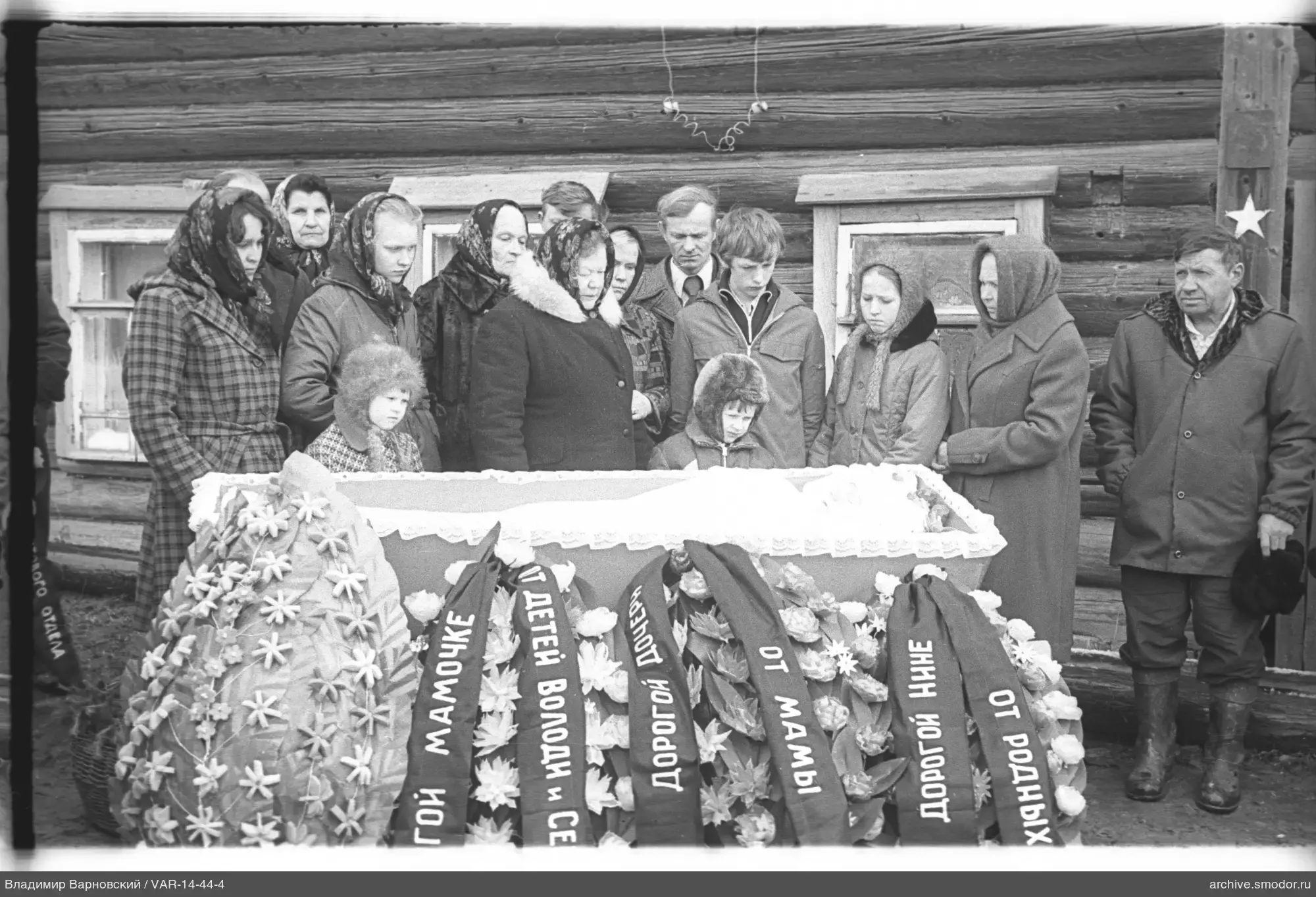 People around a coffin at a funeral