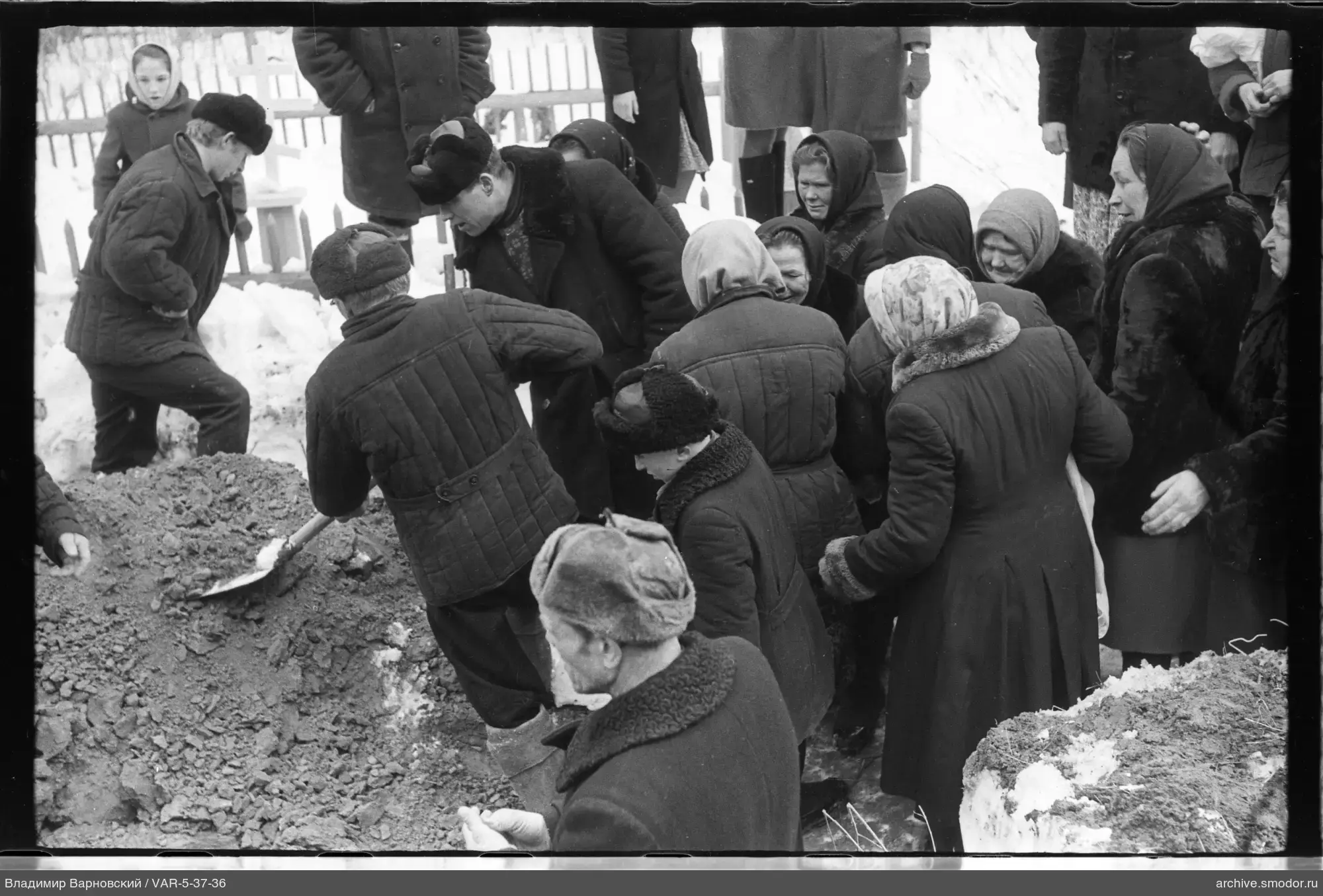 Gruppe von Menschen um eine große Grube mit Erde und Schnee