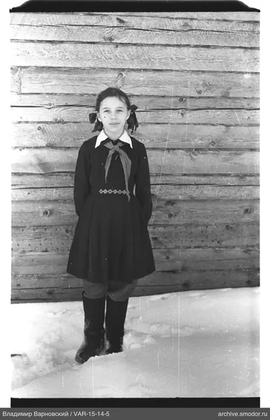 Mädchen im Schnee an einer Holzwand