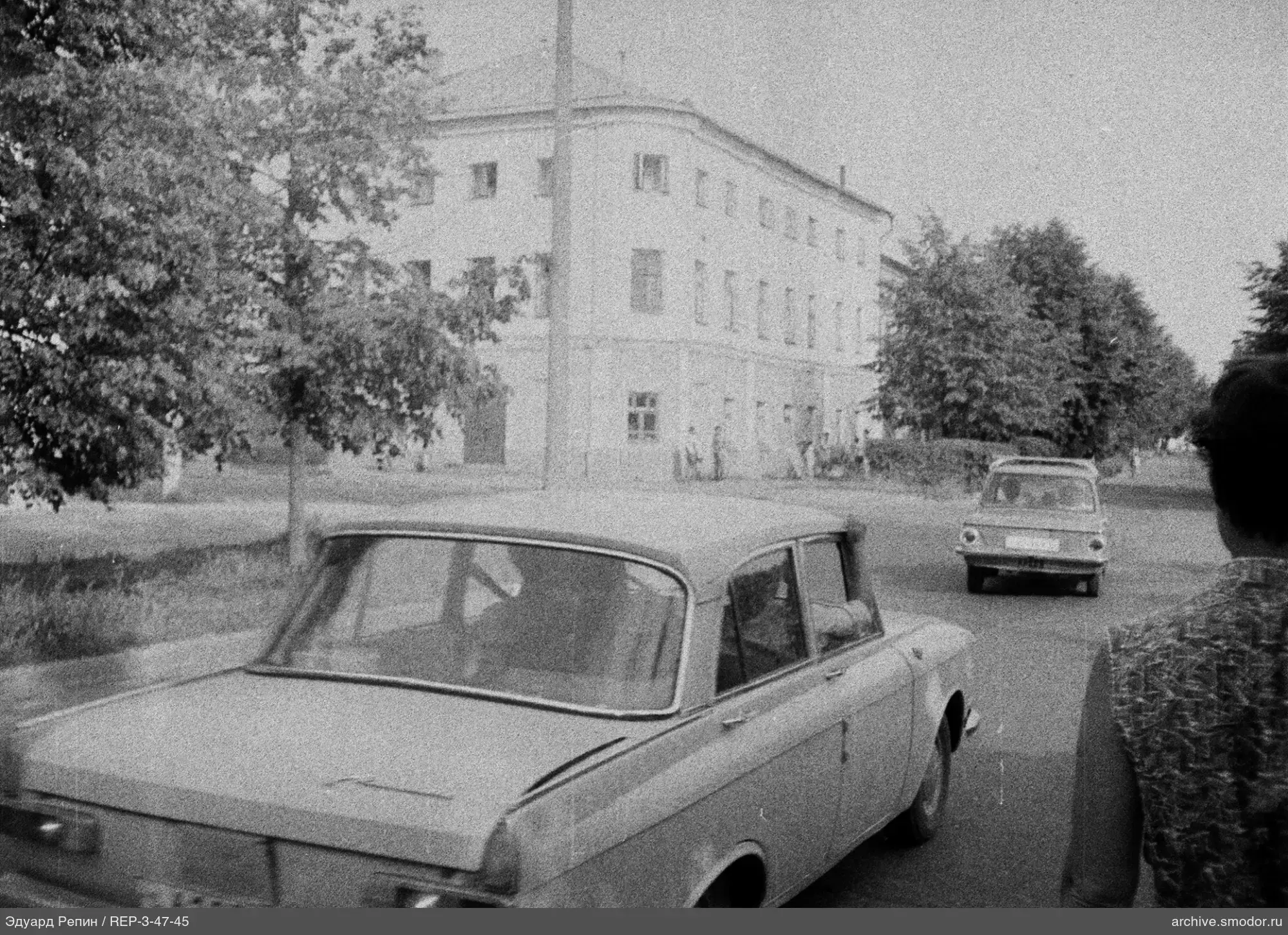 Улица с двумя автомобилями и зданием