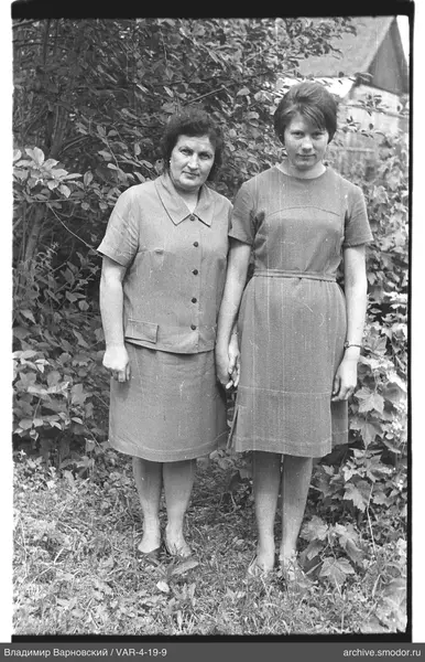 Full-length portrait of two women against foliage
