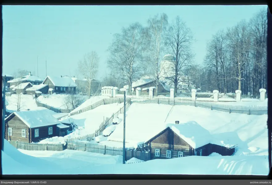 Деревянные дома и церковь на фоне деревьев