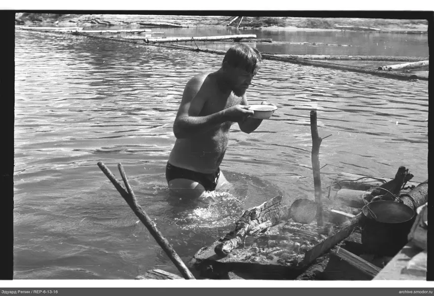 Mann im Wasser mit Schüssel am Ufer