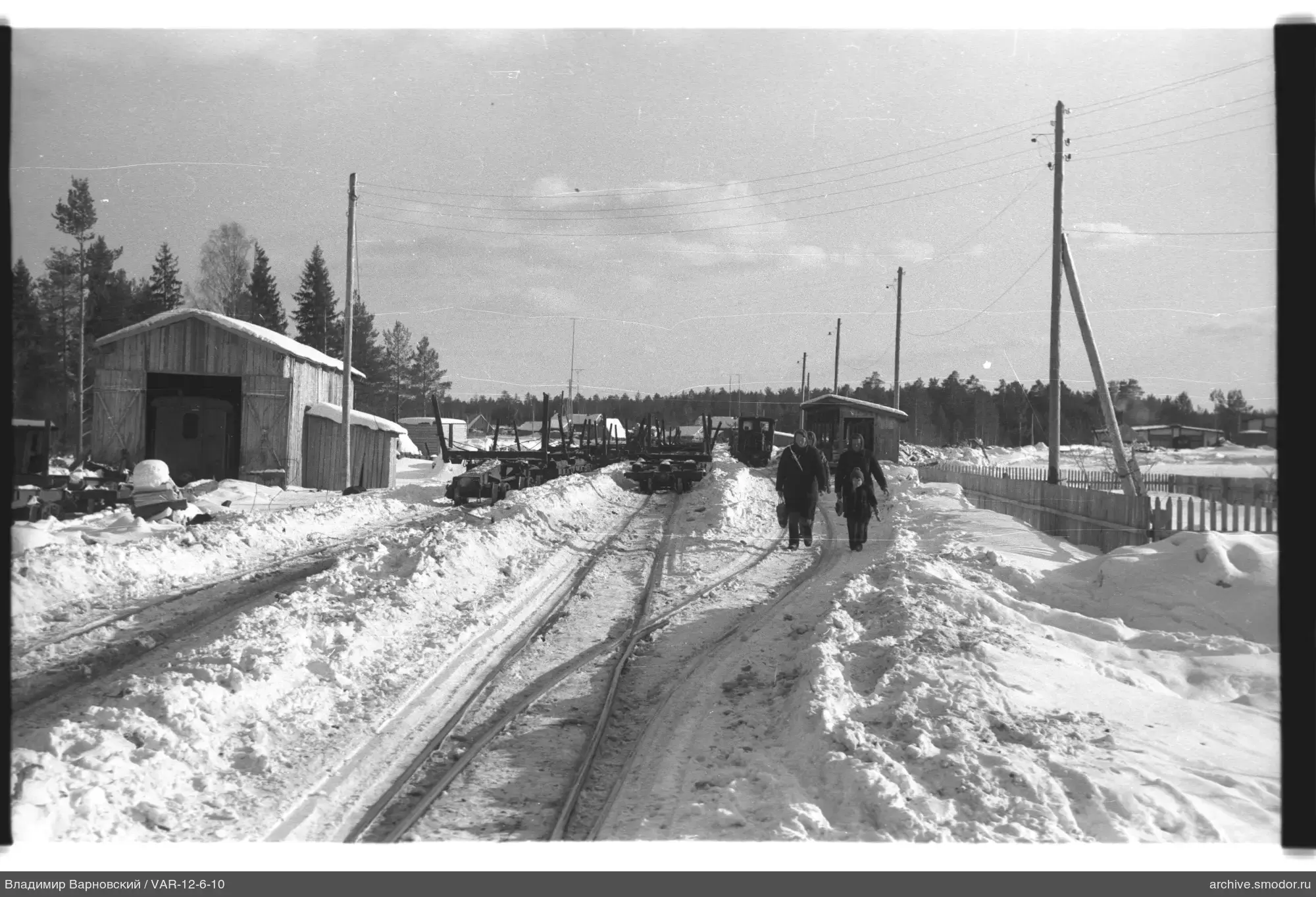 Snow-covered railway station with people