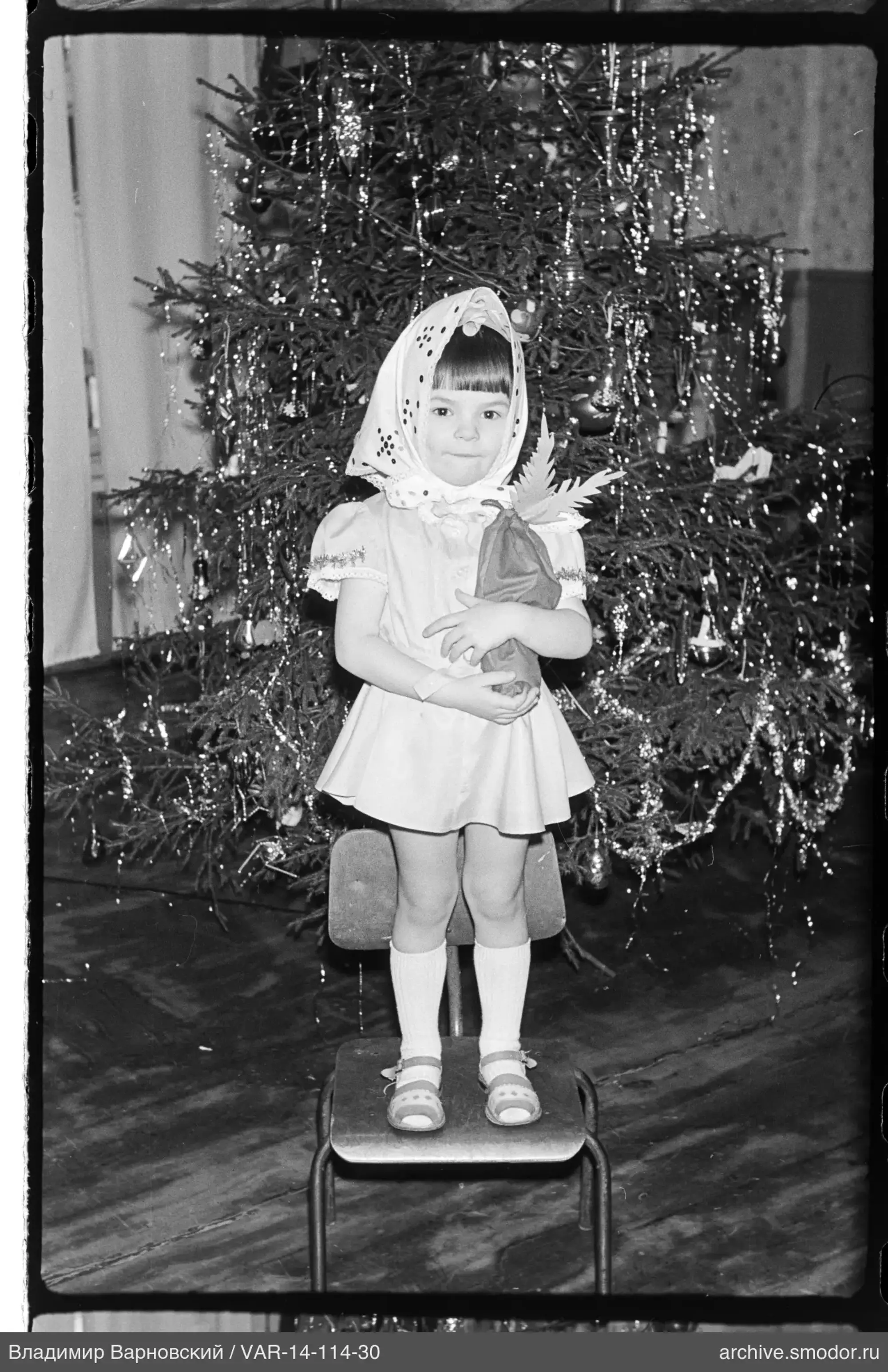 Mädchen vor geschmücktem Weihnachtsbaum