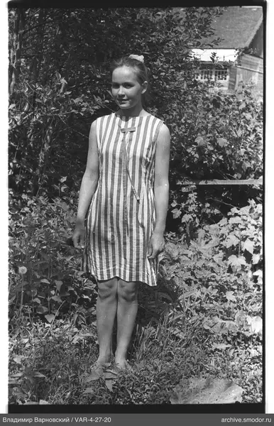 Mädchen im gestreiften Kleid auf Gras