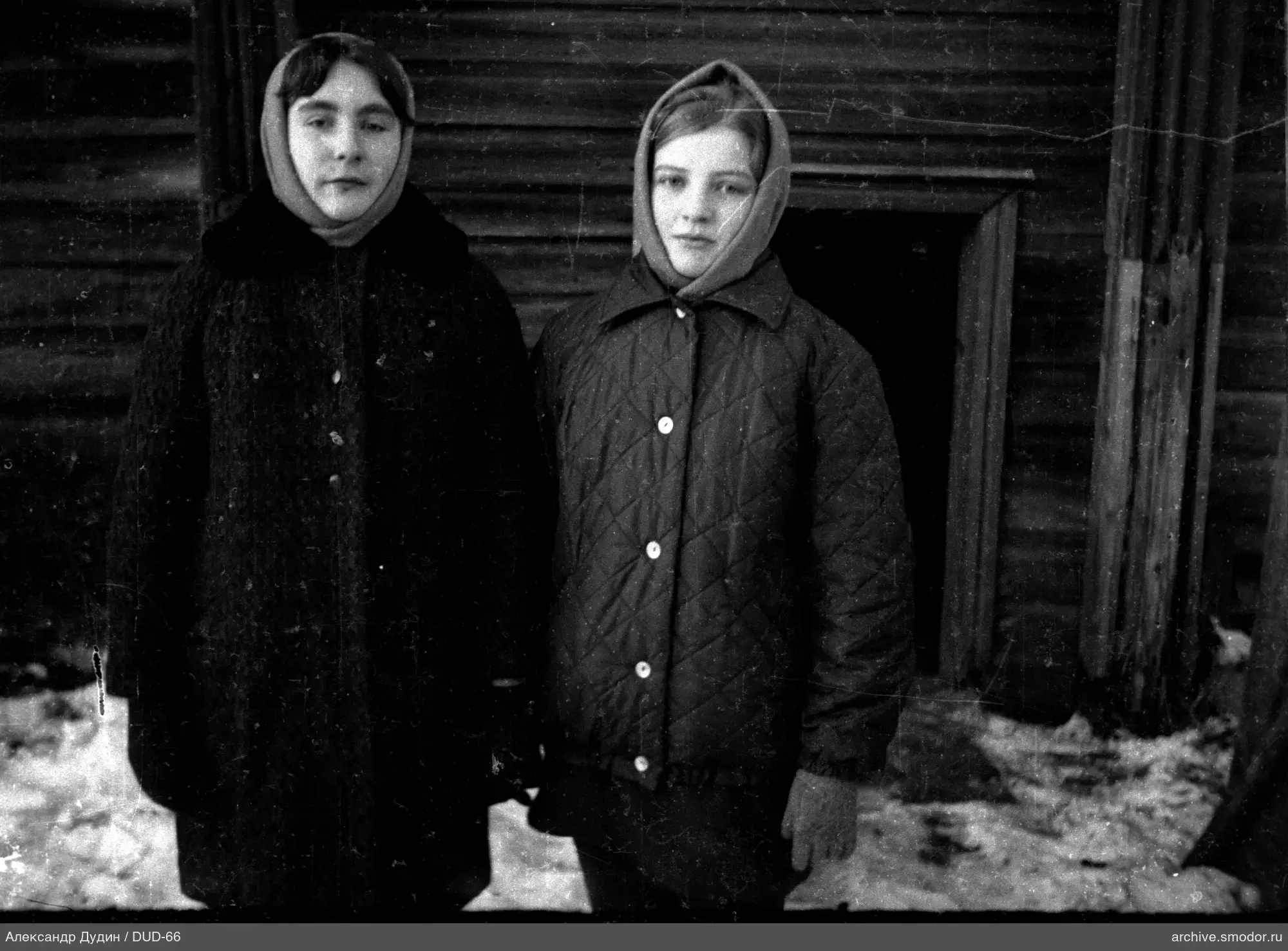 Zwei Frauen vor einem Holzgebäude auf Schnee