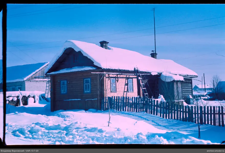 Wooden house with two chimneys and snow
