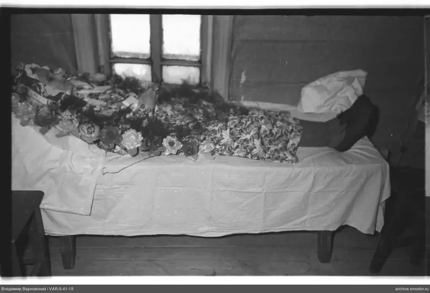 Person mit Blumen auf Bett bedeckt