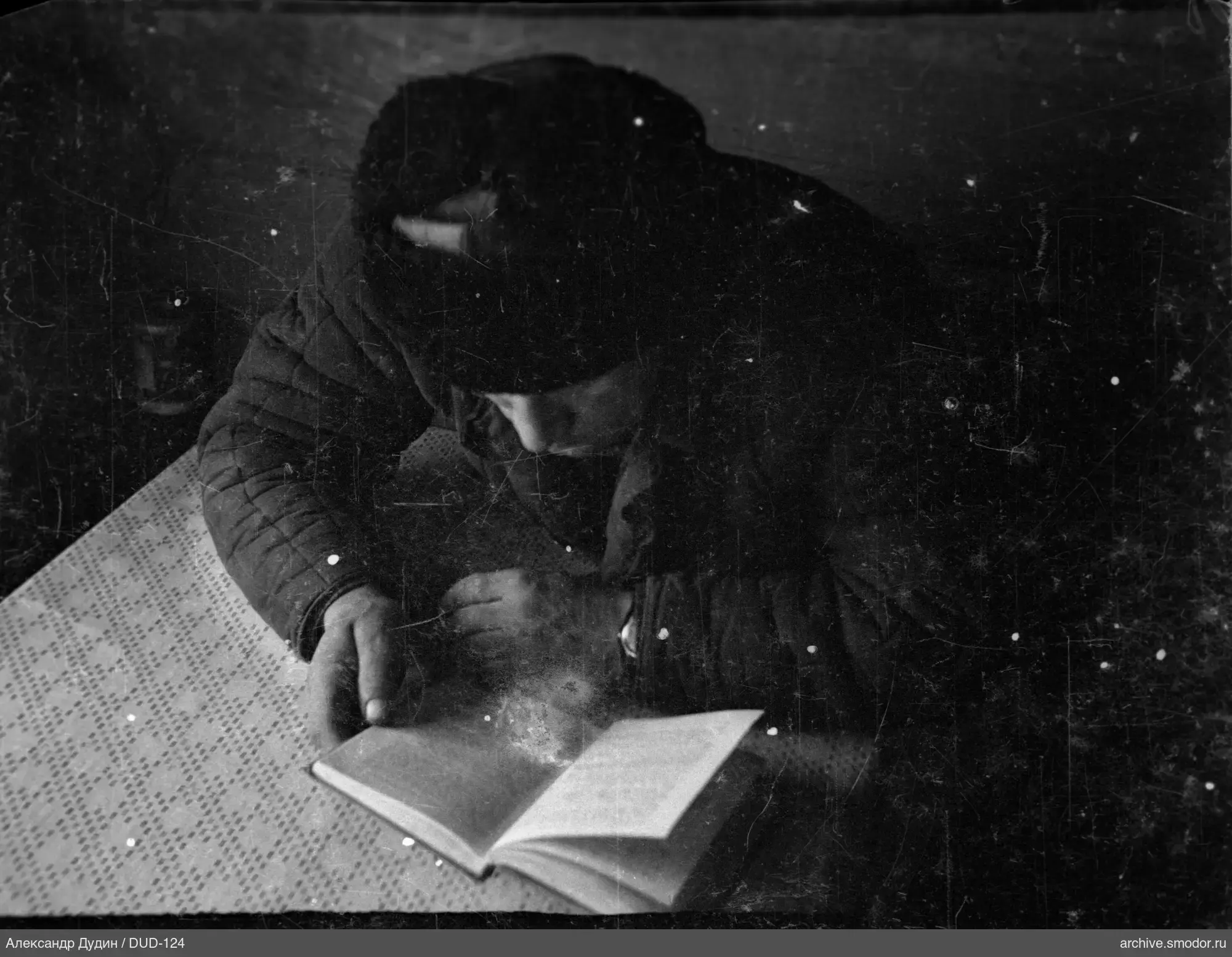 Человек с книгой у темного фона