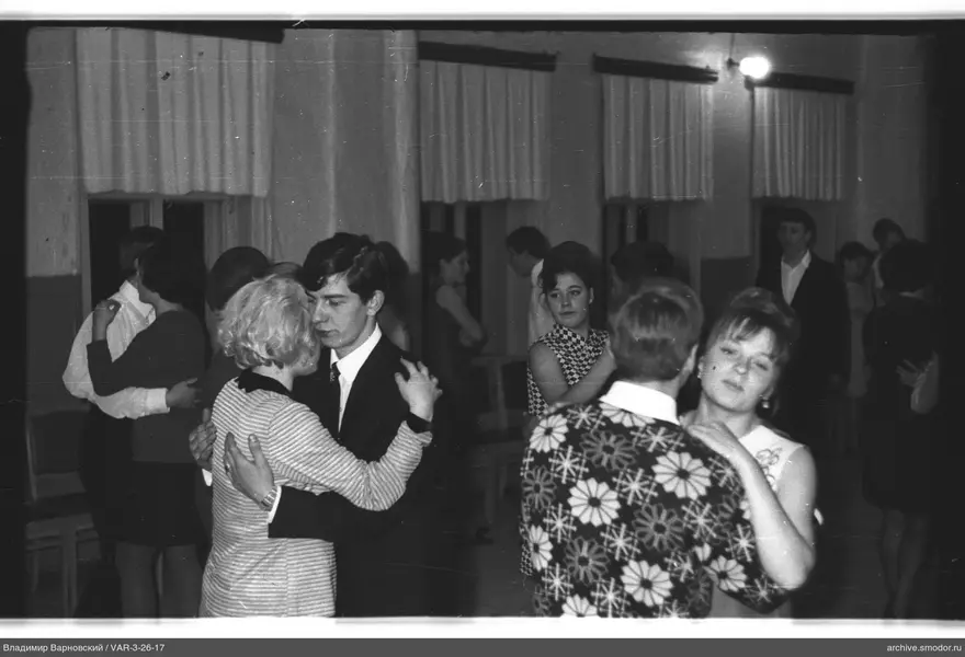 Couples dancing in a hall with curtained windows