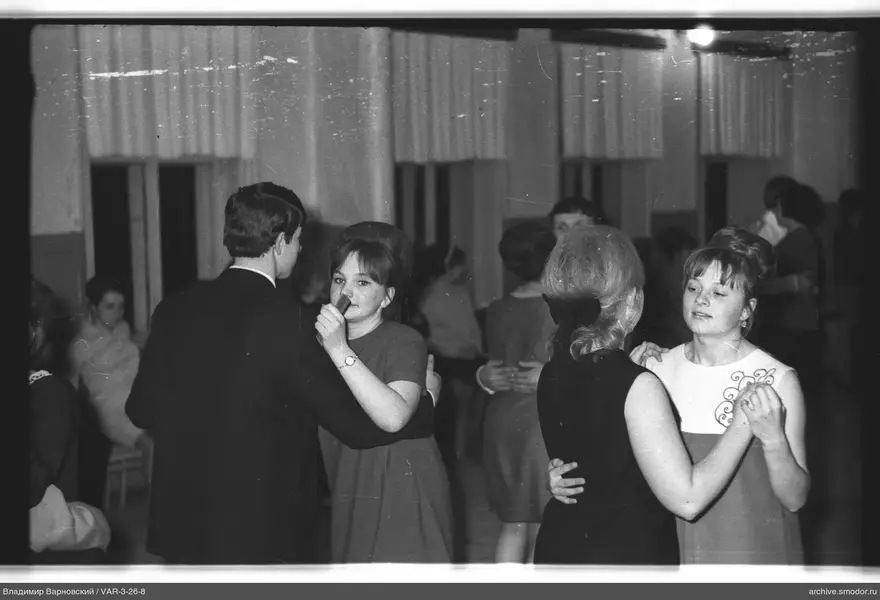 Couples dancing in a room with tall windows