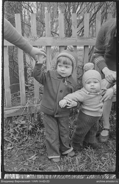 Two children by a wooden fence