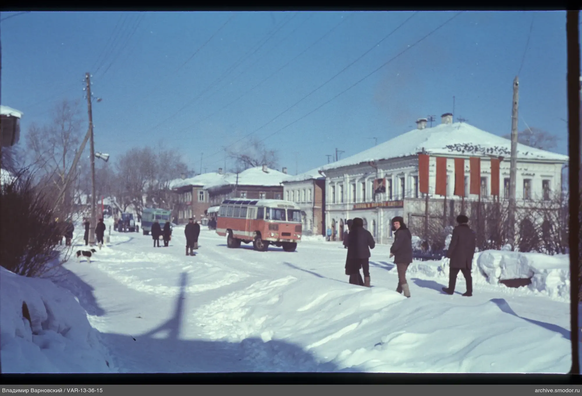 Заснеженная улица с людьми и автобусом
