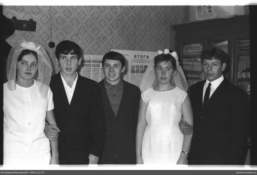 Group of five people against wallpaper with newspaper clippings