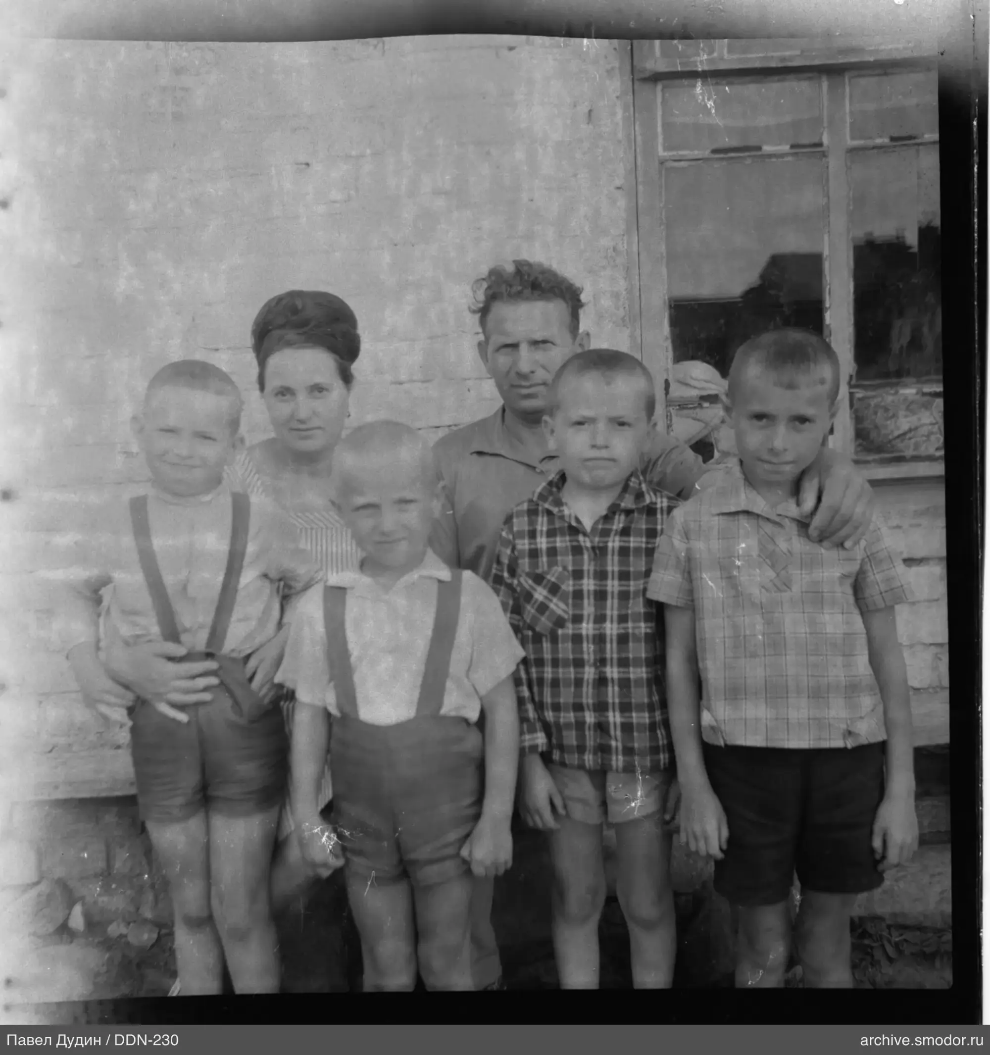 Gruppe von Erwachsenen und Kindern an der Wand