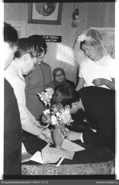 People around a table with a document and flowers