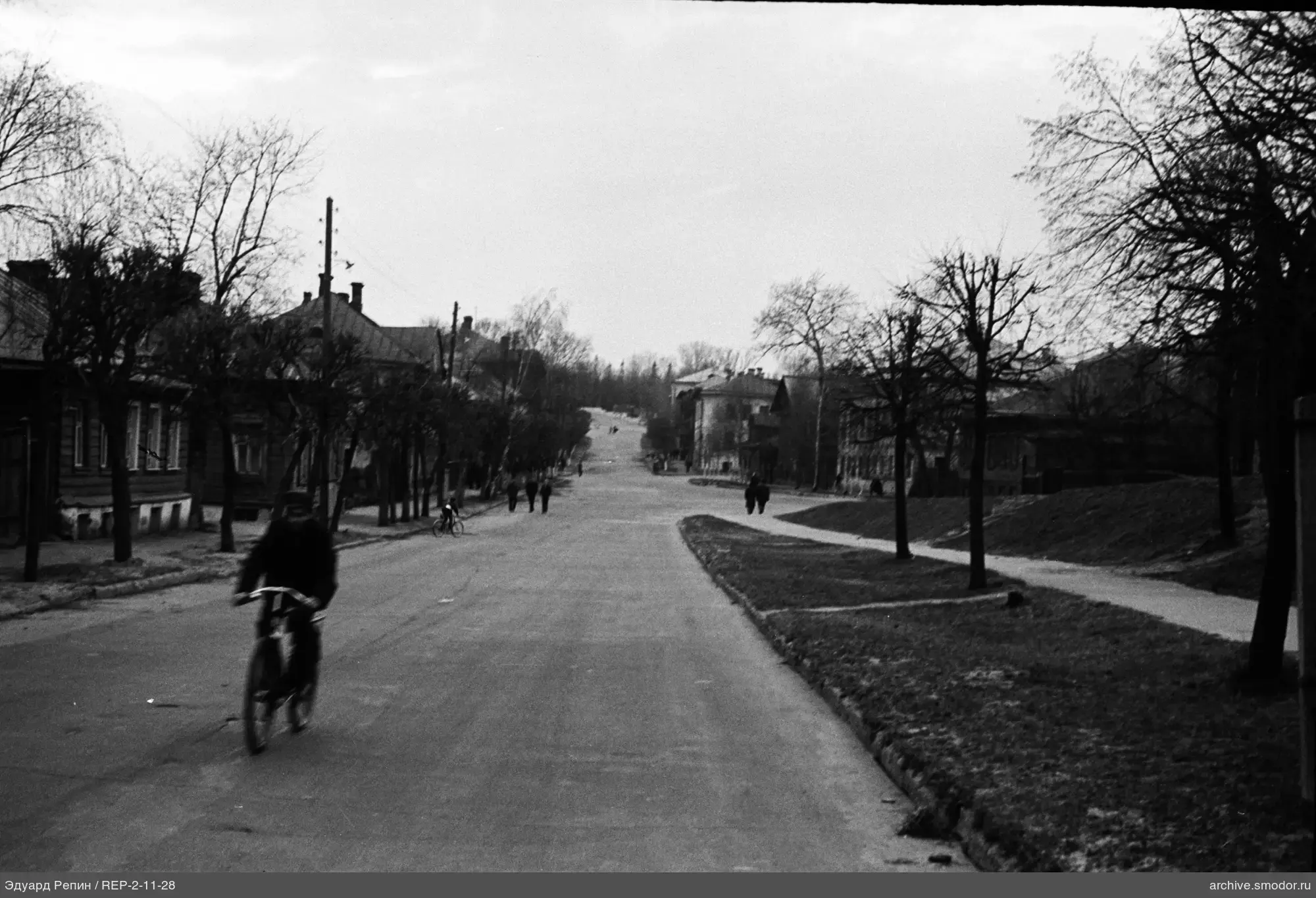 Breite Straße mit Fußgängern und Radfahrern