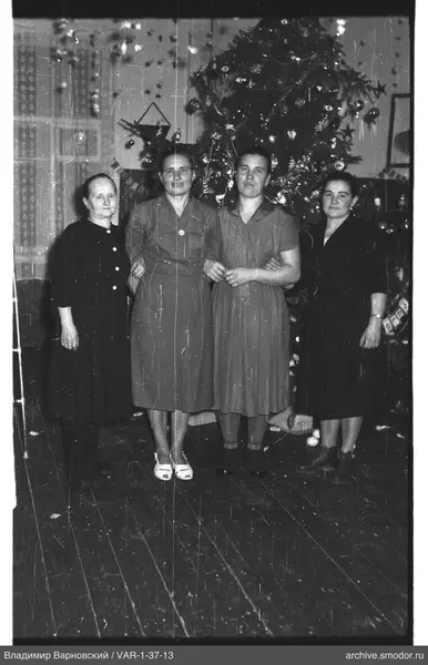 Gruppenporträt von Frauen vor Weihnachtsbaum