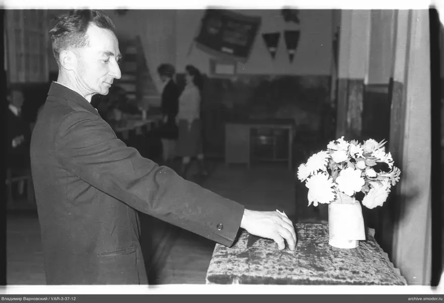Man near a table with a bouquet of flowers