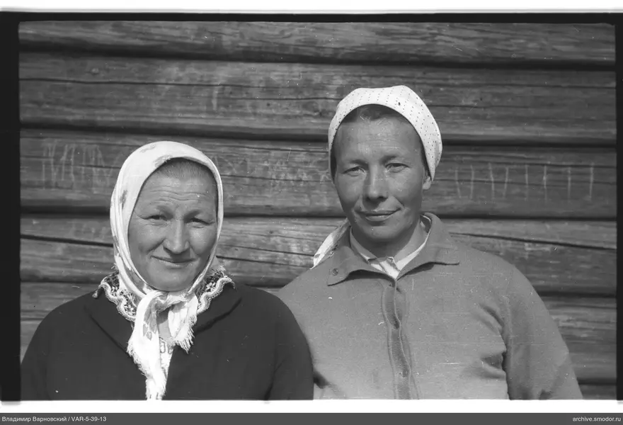 Две женщины в платках у деревянной стены