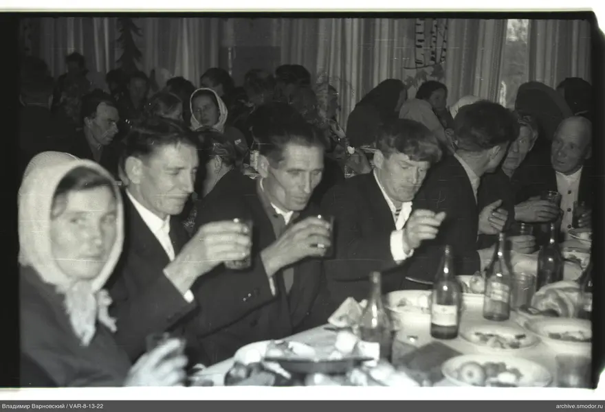 Group sitting at a table with dishes and bottles