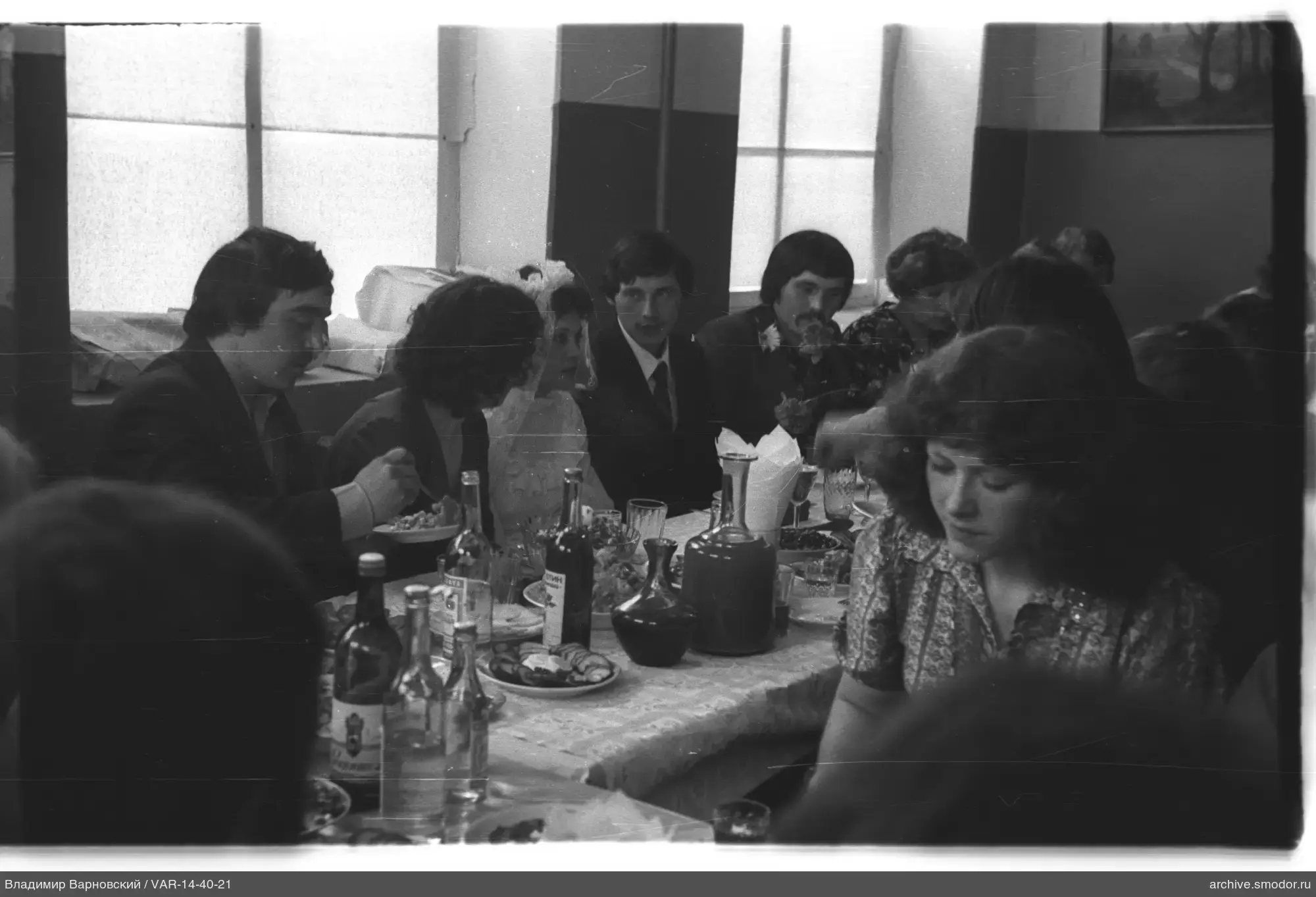 Gruppe am Tisch mit Frau im Schleier
