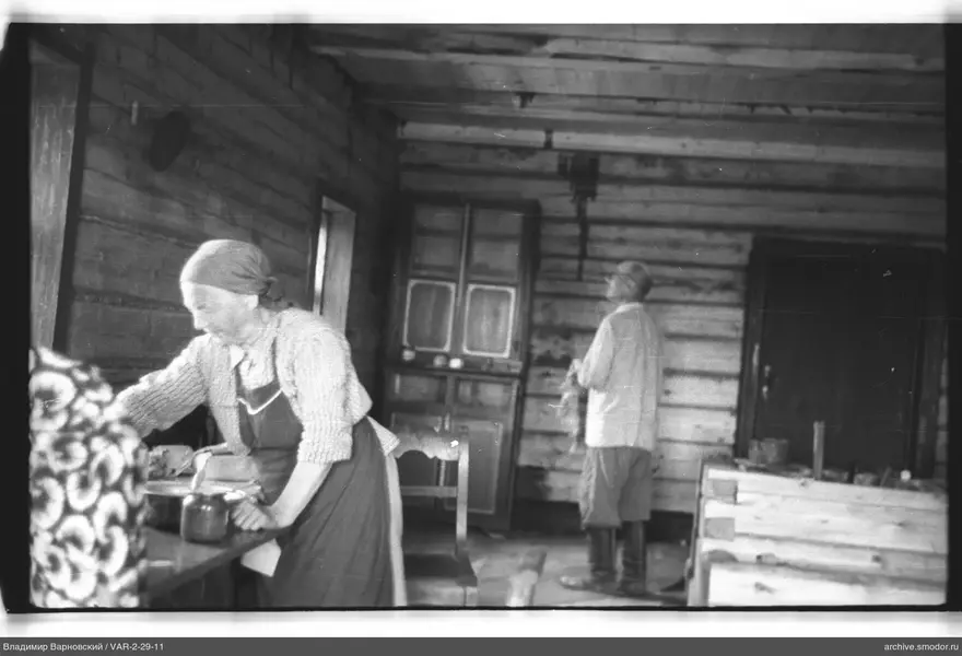Two women inside a wooden house