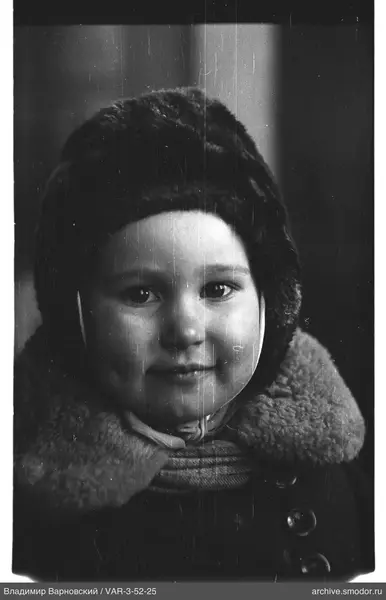 Child's portrait in dark coat and headgear
