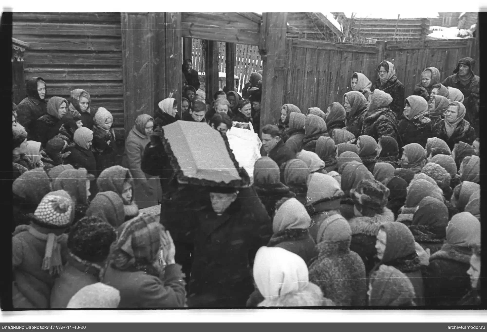 Group of people near a wooden fence