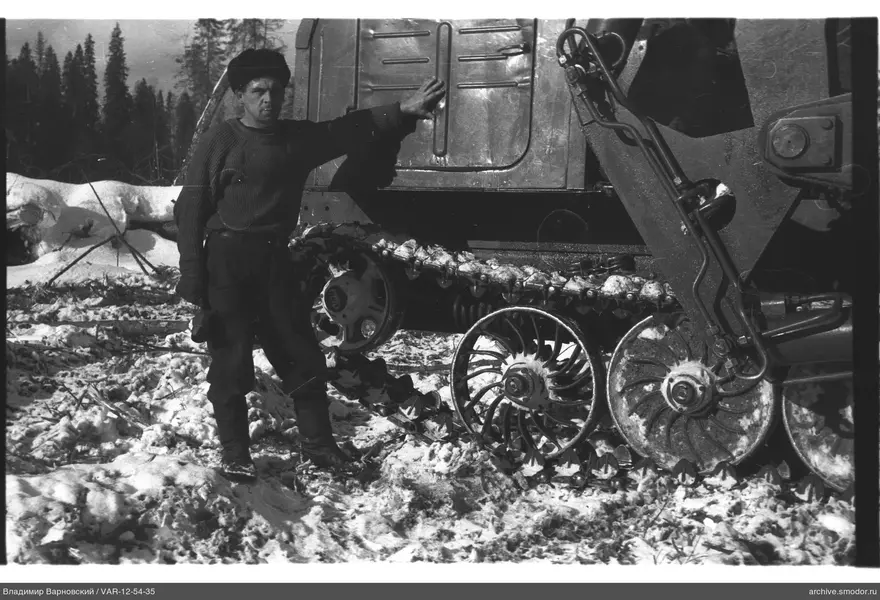 Mann mit Kettentraktor im Schnee