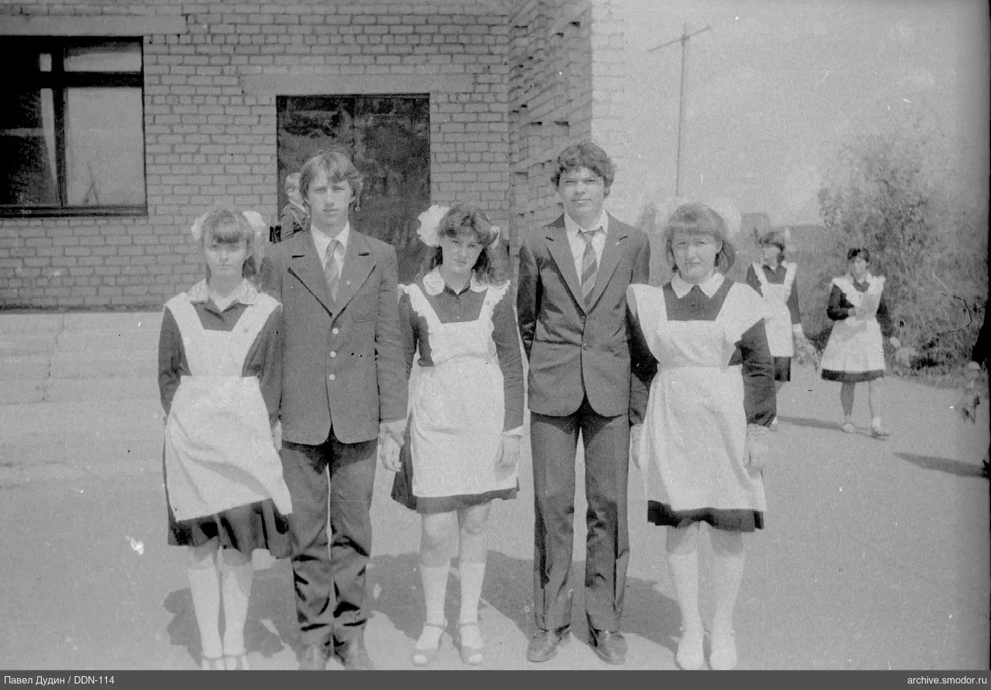 Group portrait of teenagers near a brick building