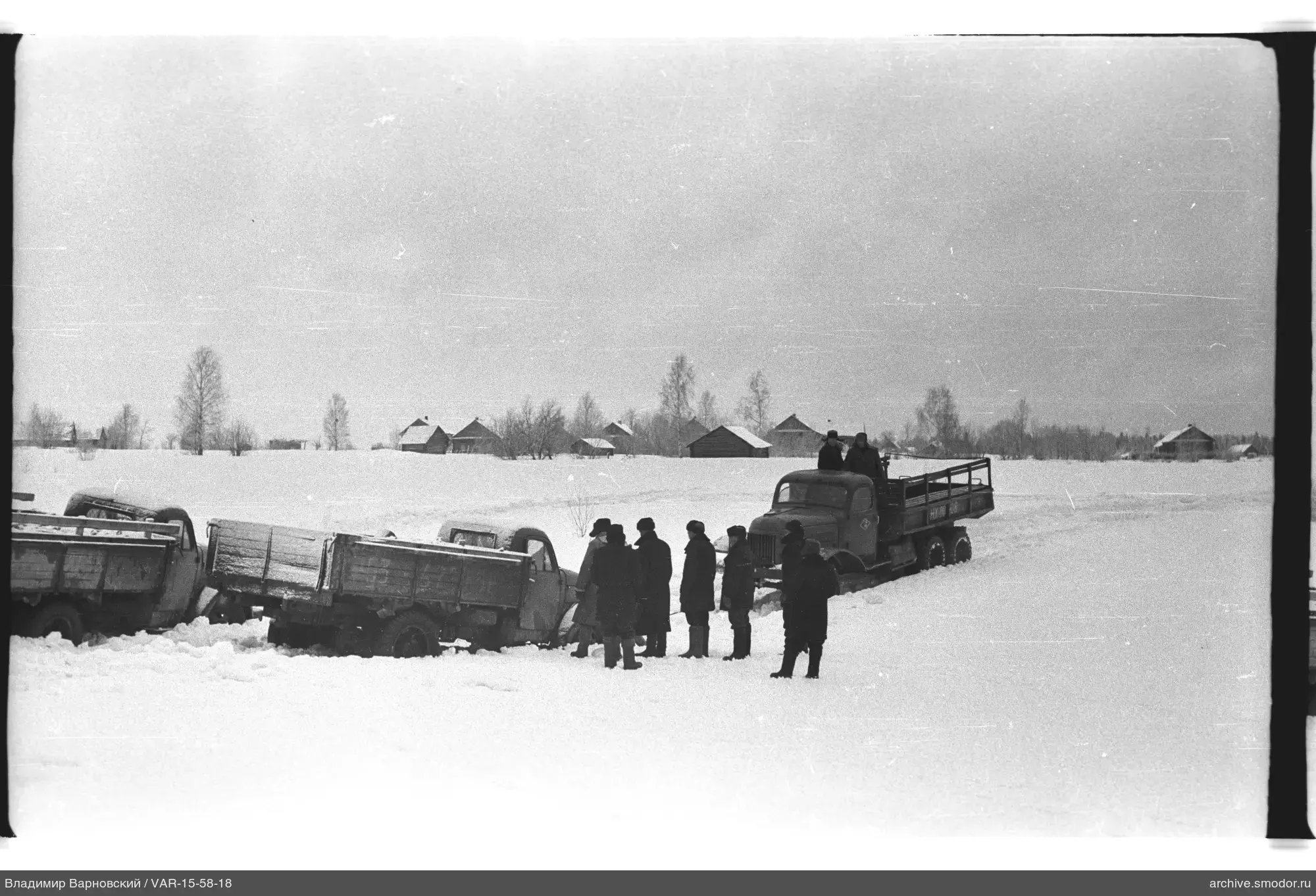 Männer und Lastwagen auf verschneitem Feld