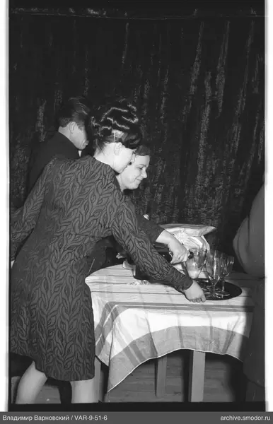 People at a table with bouquet and drinks