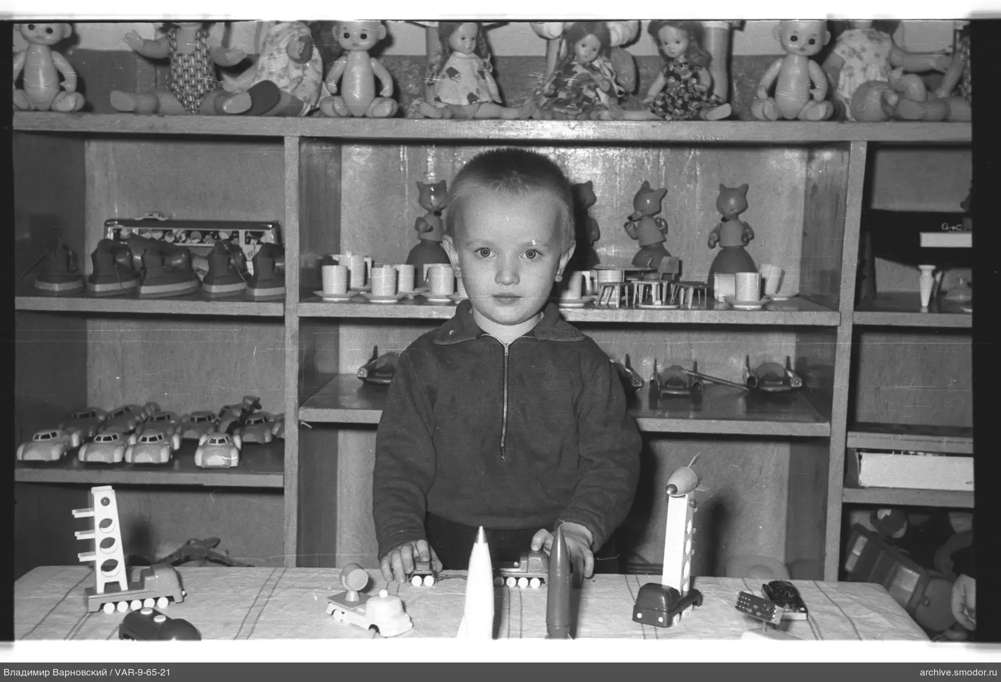 Ребёнок с игрушечными моделями на столе