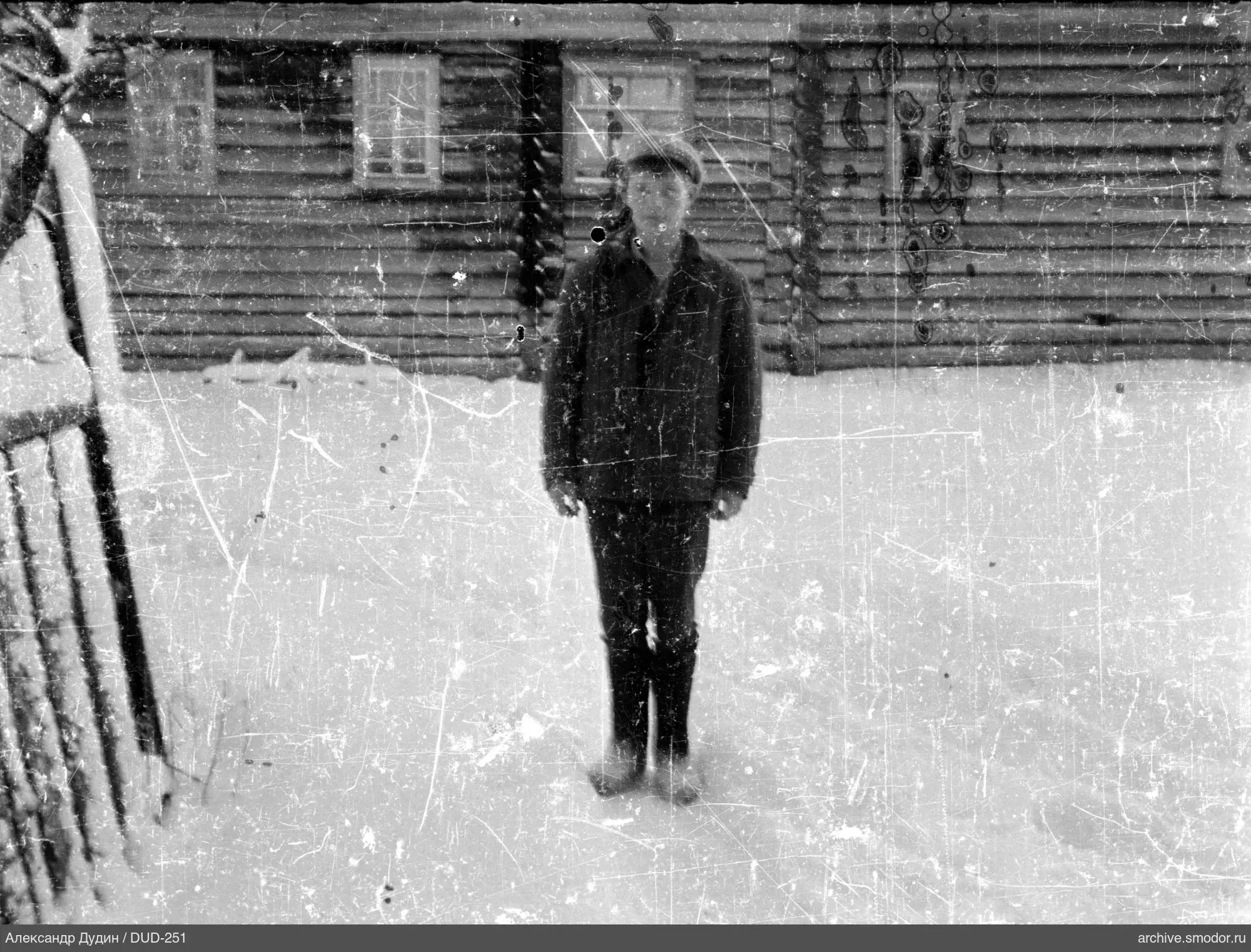 Портрет мальчика на снегу перед домом