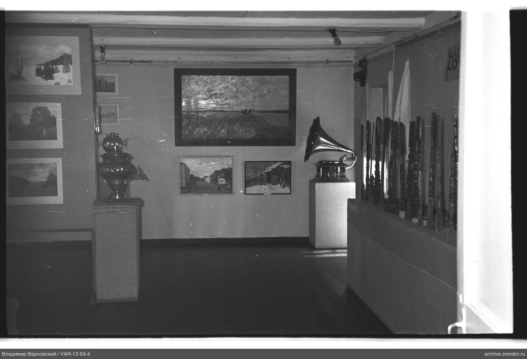 Ausstellungsraum mit Gemälden und Holzarbeiten