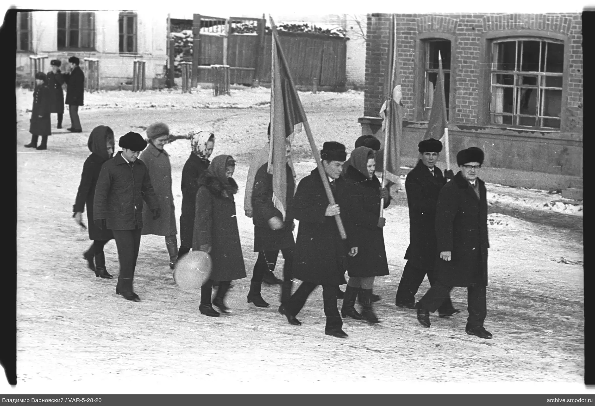 Gruppe von Menschen mit Fahnen auf verschneiter Straße