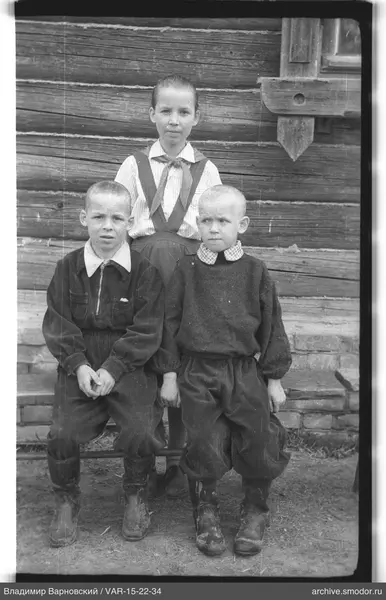 Gruppenporträt von Kindern vor einer Holzwand